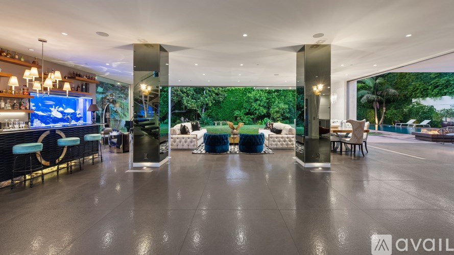 A modern indoor space with a bar area and a view of the outdoors through a glass wall.