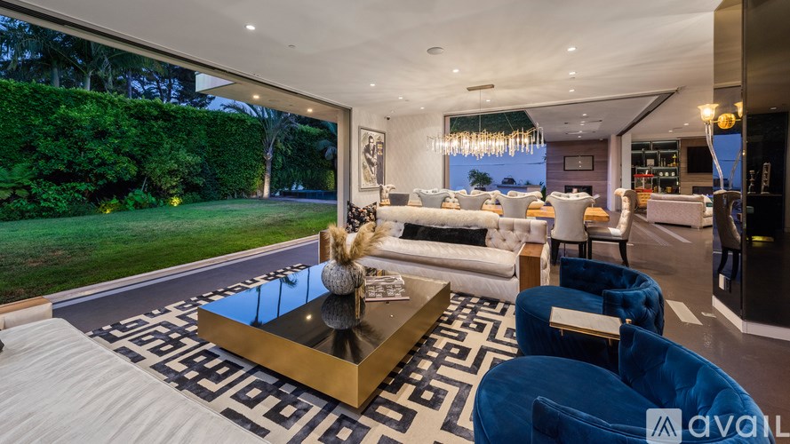 A modern living room with a large coffee table and blue chairs.