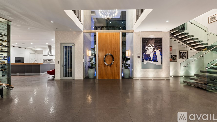 A modern interior with a wooden door and glass staircase.