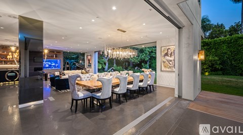 A modern dining room with a long table set for a meal.