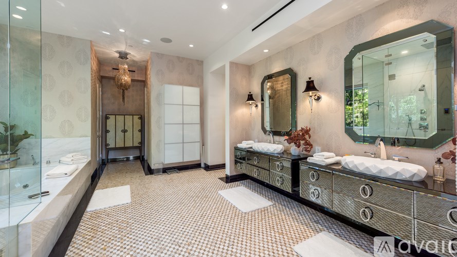 A bathroom with a glass shower stall, a sink, and a mirror.