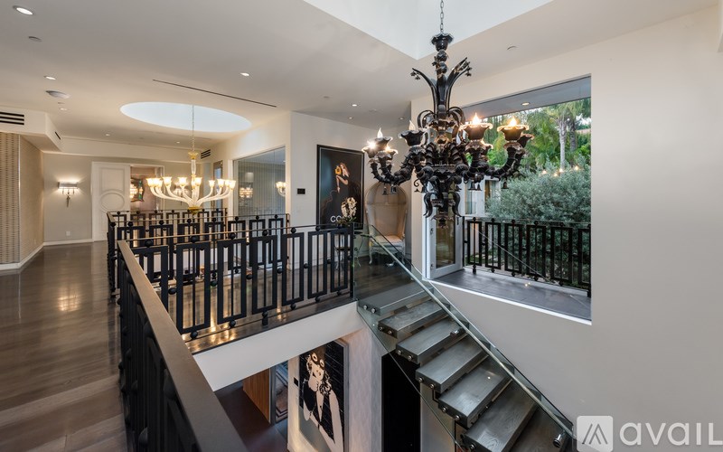 A large, ornate chandelier hangs from the ceiling in a spacious, well-lit room.