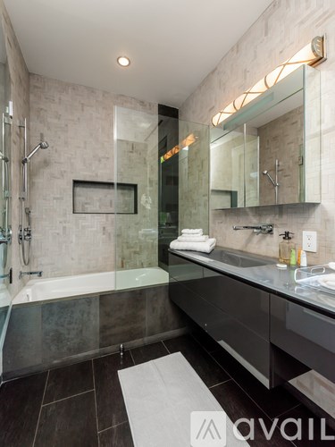 A modern bathroom with a glass shower and a white towel.
