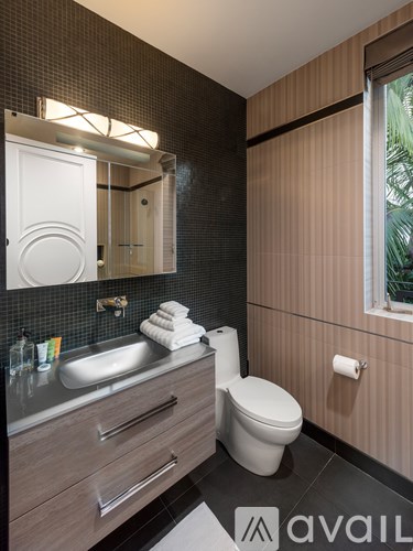 A bathroom with a sink, toilet, and mirror.