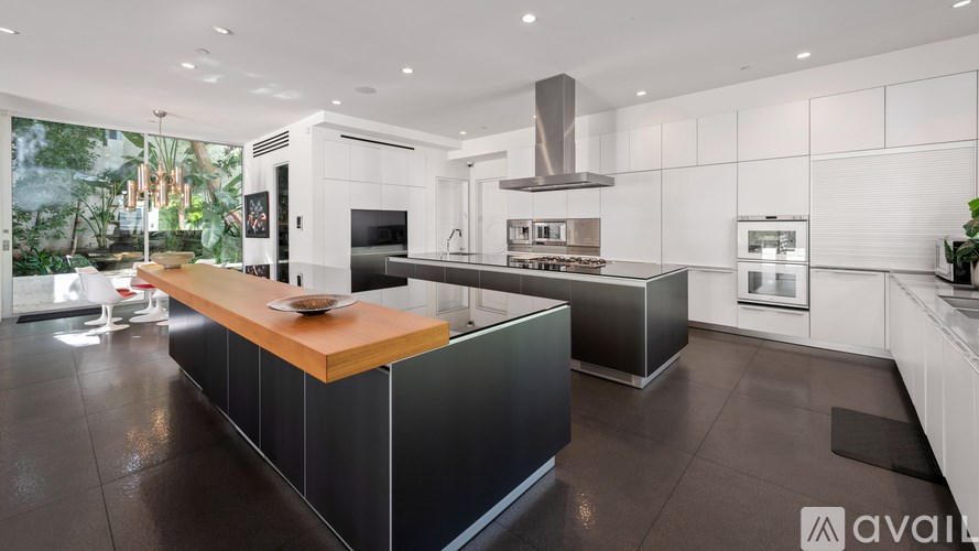 A modern kitchen with a wooden island in the middle.