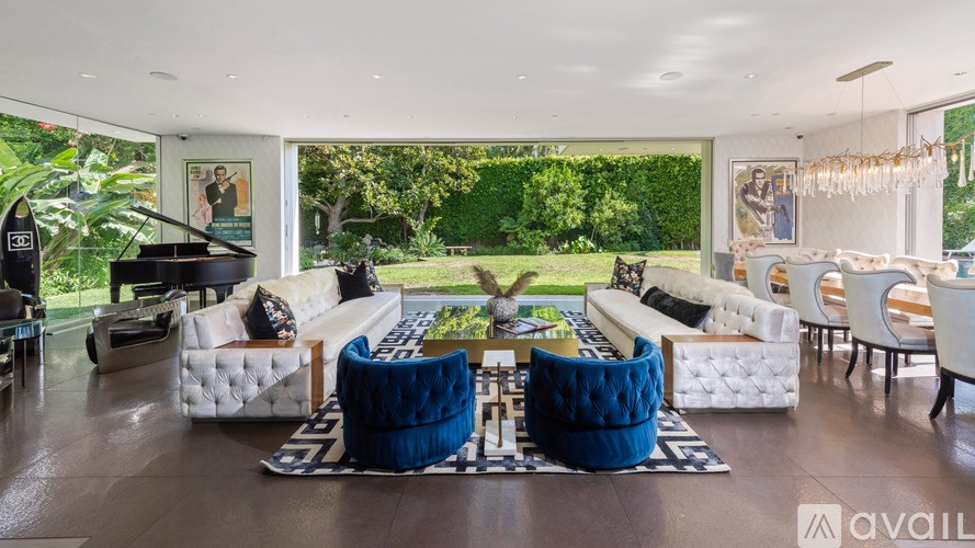 A living room with white furniture and a piano.