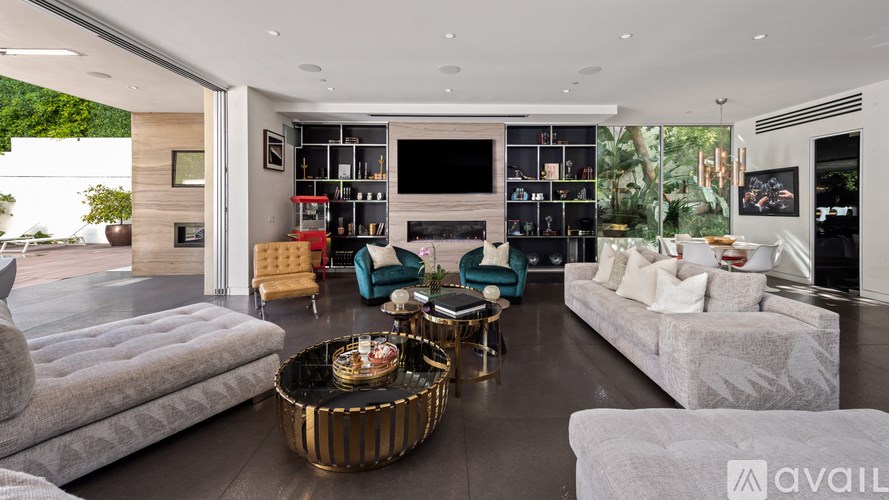 A modern living room with a grey sofa, a gold coffee table, and a TV on the wall.