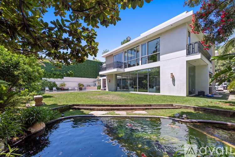 A modern house with a pool in the foreground.