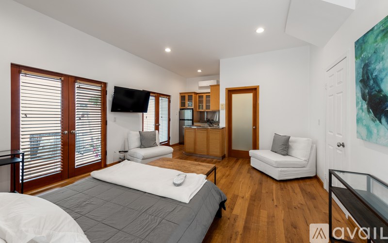 A bedroom with a large bed and a television on the wall.