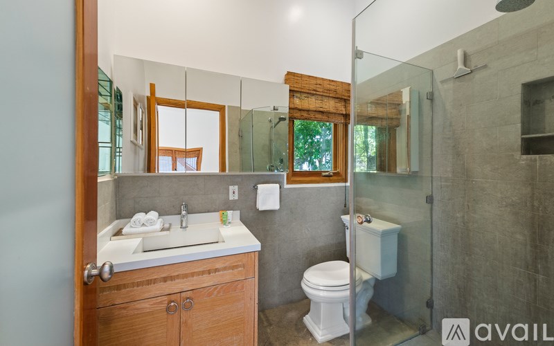 A bathroom with a toilet, sink, and shower.