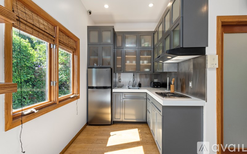A kitchen with a refrigerator, stove, and cabinets.