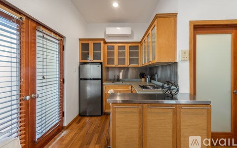 A kitchen with wooden cabinets and a black fridge.