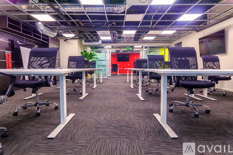A conference room with a carpeted floor and a red wall in the background.