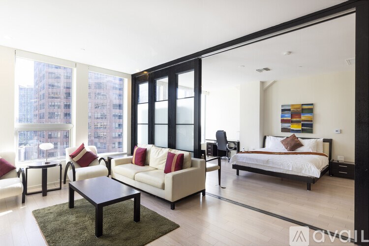 A bedroom with a bed, a couch, and a chair.