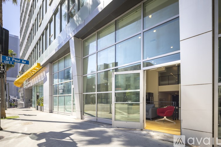 A modern building with a glass facade and a yellow awning on the corner.