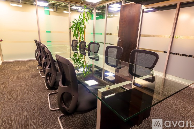 A row of black chairs are lined up in a waiting area.
