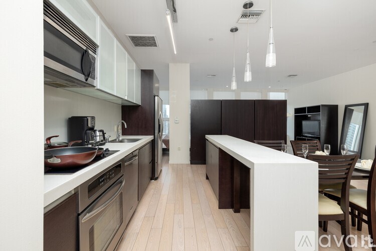 A modern kitchen with dark wood cabinets and stainless steel appliances.
