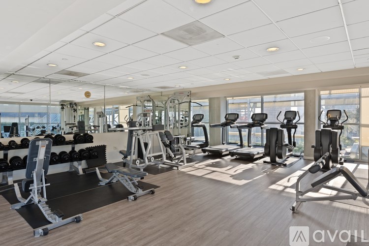 A gym with a variety of equipment including treadmills, weights, and exercise machines.