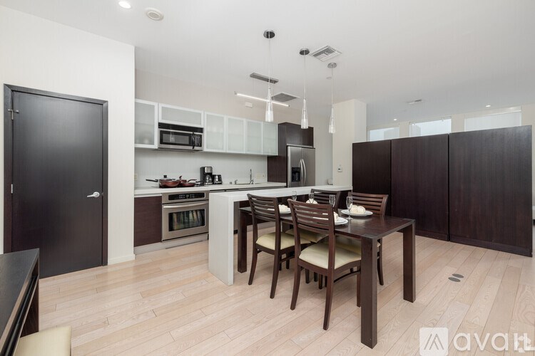 A modern kitchen with dark wood floors and furniture.