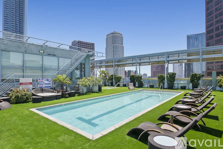 A pool with loungers and a glass wall in the background.