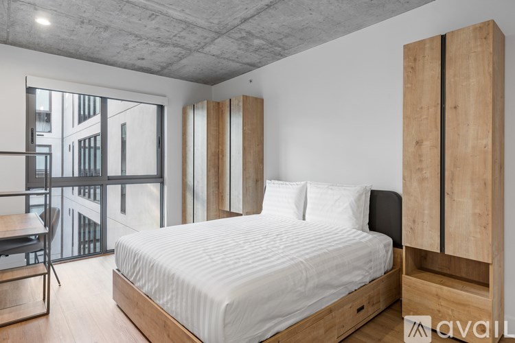 A bedroom with a large bed and a balcony with a table and chairs.