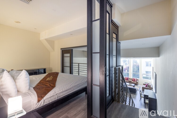 A bedroom with a large bed and a staircase leading to the upper floor.