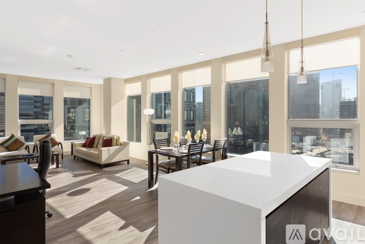 A modern living room with a kitchen island in the middle.