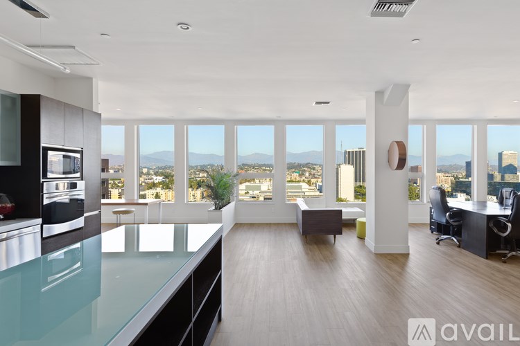 A modern kitchen with a glass countertop and a view of the city.