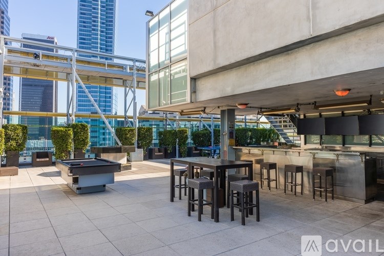 A rooftop bar with a pool table and stools.