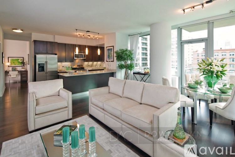 A modern living room with a kitchen in the background.