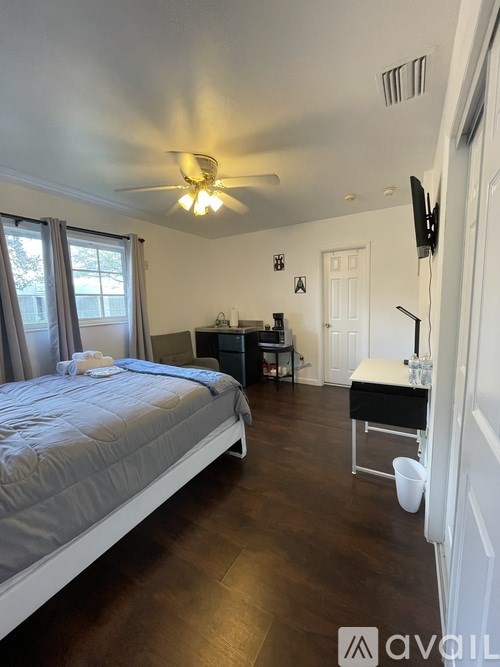 A bedroom with a bed, desk, and chair.
