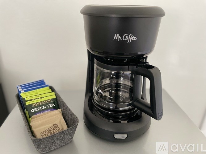 A Mr. Coffee coffee maker with a basket of tea bags.