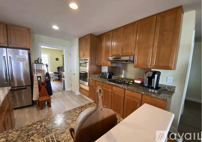 A kitchen with wooden cabinets and a marble countertop.