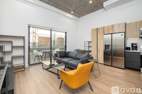 A modern living room with a black sofa and a yellow chair.