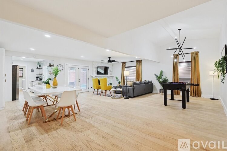 A spacious living room with a dining table and chairs.