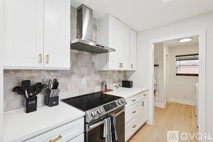 A kitchen with white cabinets and a black stove top.
