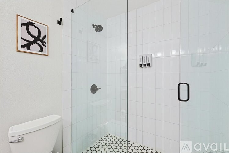 A bathroom with a white toilet and a glass shower stall.