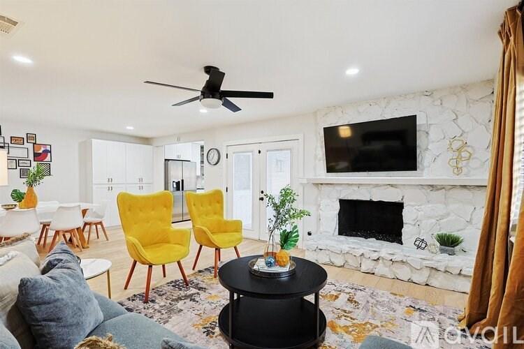 A living room with a fireplace and a TV mounted on the wall.