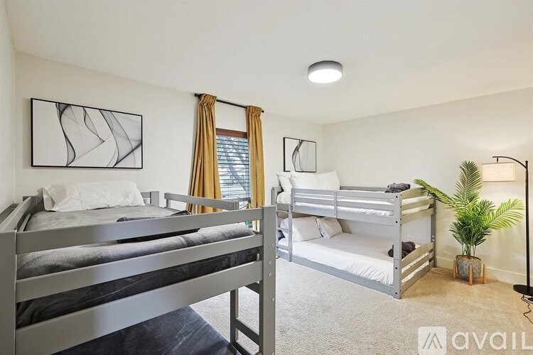 A bedroom with two beds and a plant.