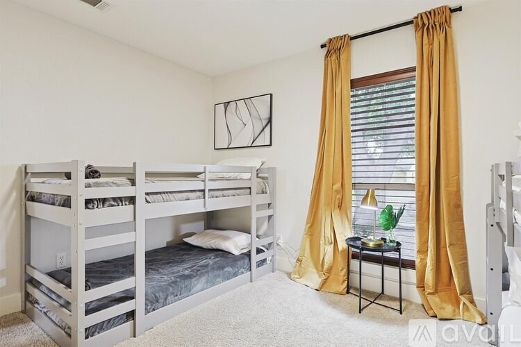 A room with bunk beds and a small table with a plant on it.