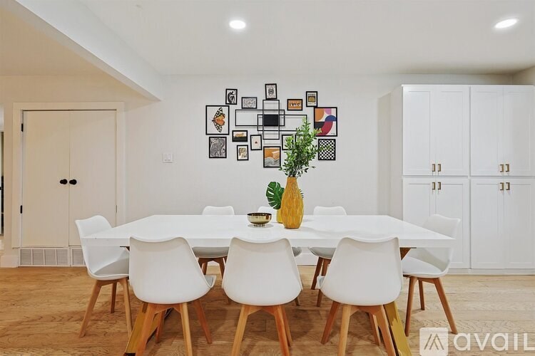 A dining room with a white table and chairs.