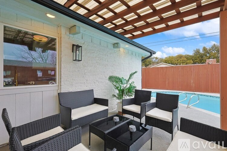 A patio with a table and chairs under a roof.