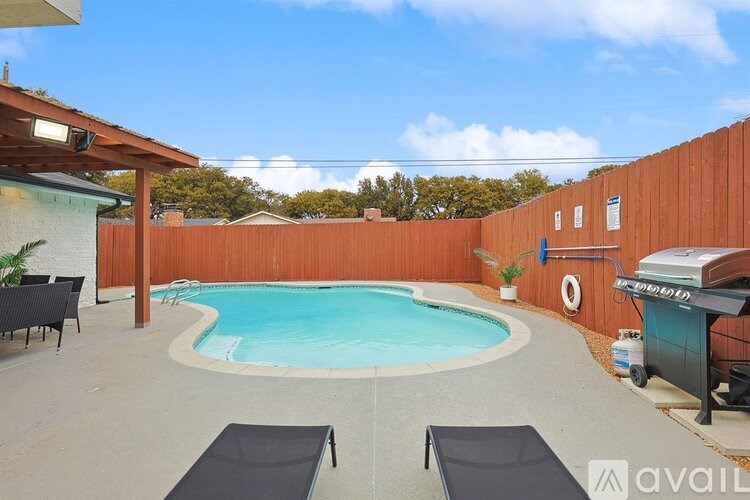 A backyard with a pool and lounge chairs.