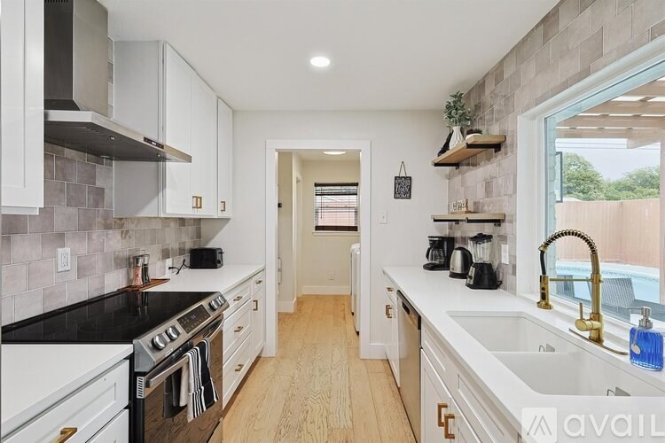 A kitchen with white cabinets and black countertops.