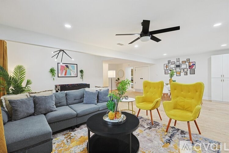 A living room with a grey sofa, yellow chairs, and a black coffee table.