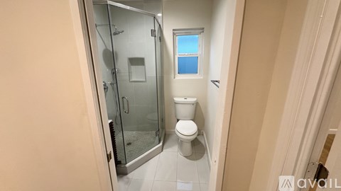 A small bathroom with a toilet and a walk-in shower.