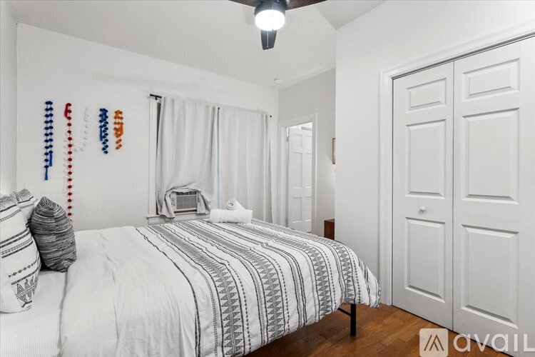 A bedroom with a bed, pillows, and a striped comforter.
