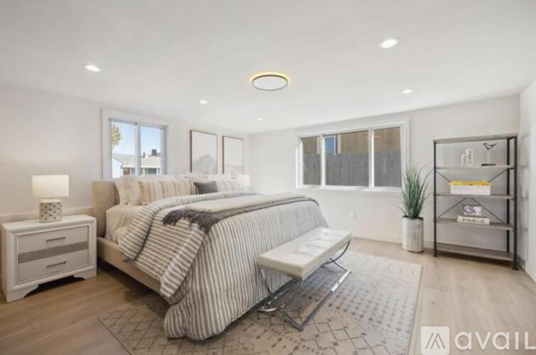 A bedroom with a large bed and a bench.