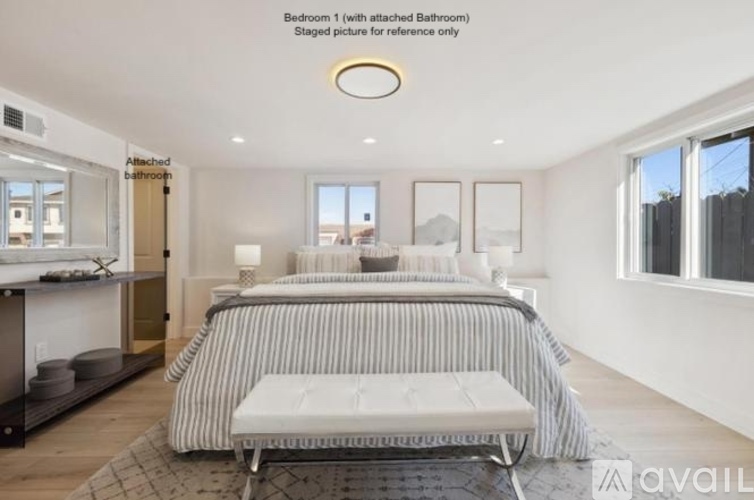 A bedroom with a large bed and a bench in front of it.