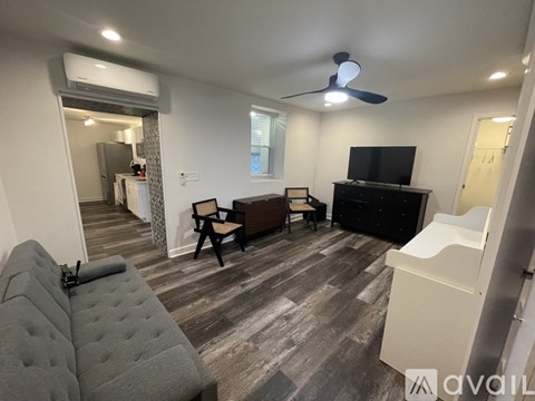 A living room with a grey sofa and a black television.